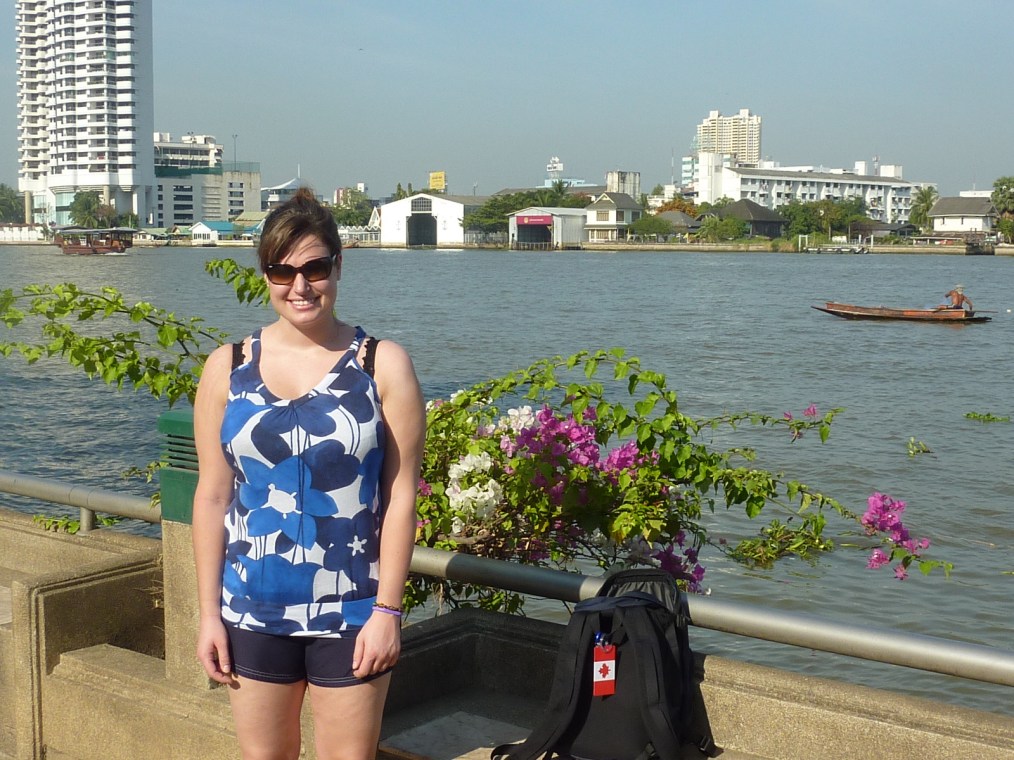 A fisherman tries for his daily catch as Meg poses beside the famous Chao Phraya river.